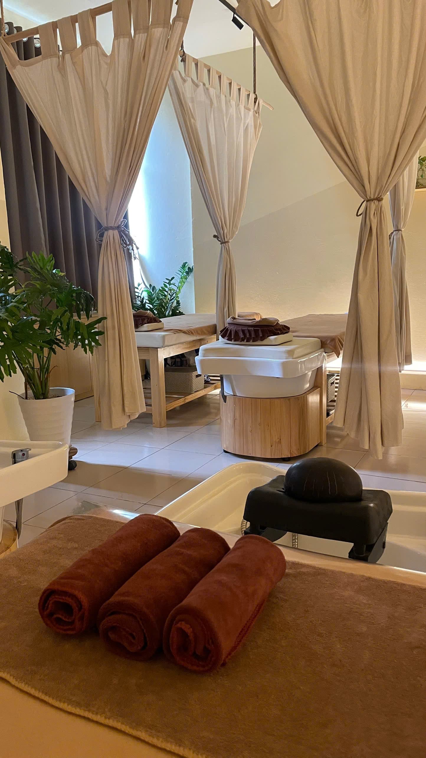Head spa treatment room at Tropi Q Hanoi — warm tropical interior with curtains and massage beds